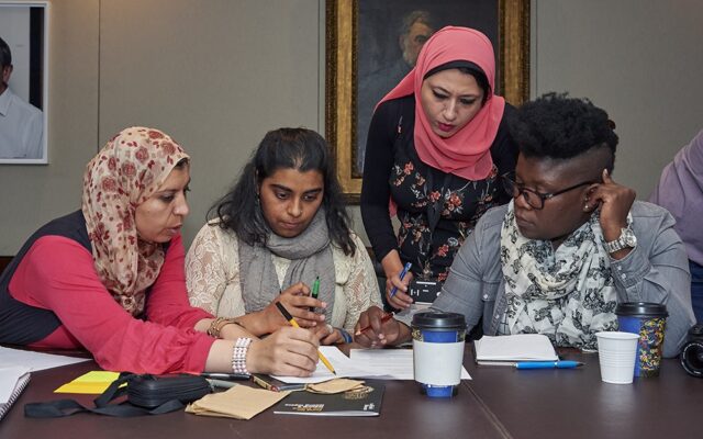 A group of four ITP participants make notes together at a table as part of a group activity.