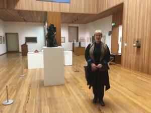 ITP fellow Barbara Vujanović stands in a museum gallery next to a statue of man sitting with his head resting in his hand. 