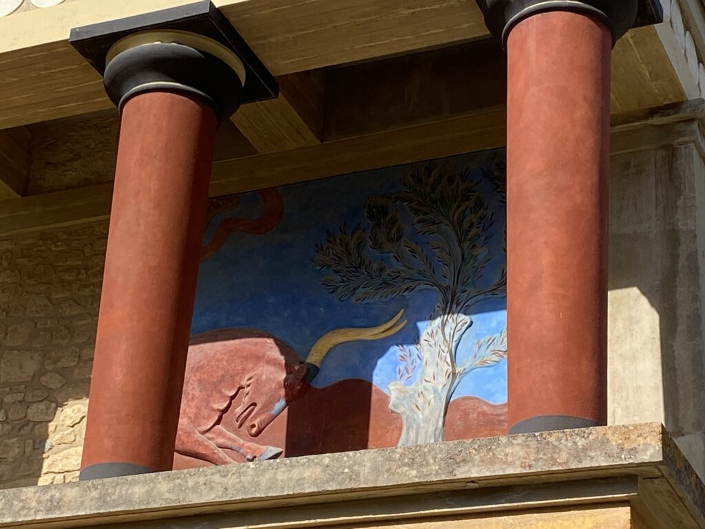 Red columns and wall painting of a tree and bull at Knossos