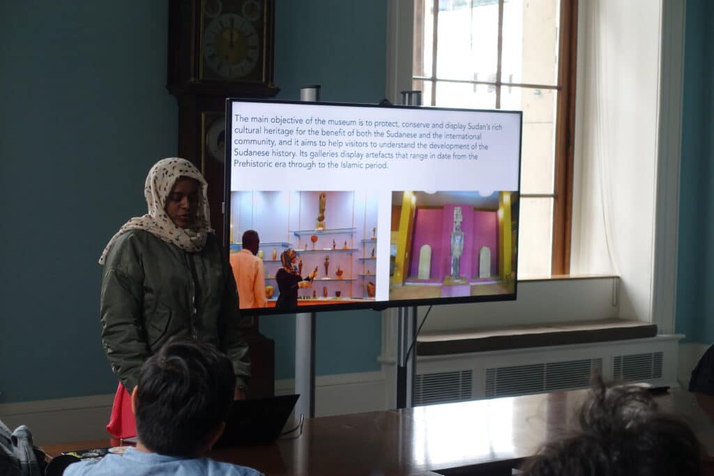 Nosiba gives a presentation next to a TV screen