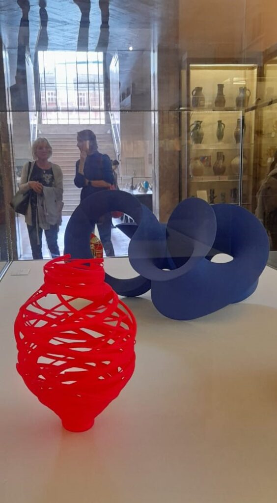 Contemporary art sculptures in red and blue sit in a museum gallery