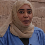 Asmahan Gabir, wearing a light coloured headscarf and blue top