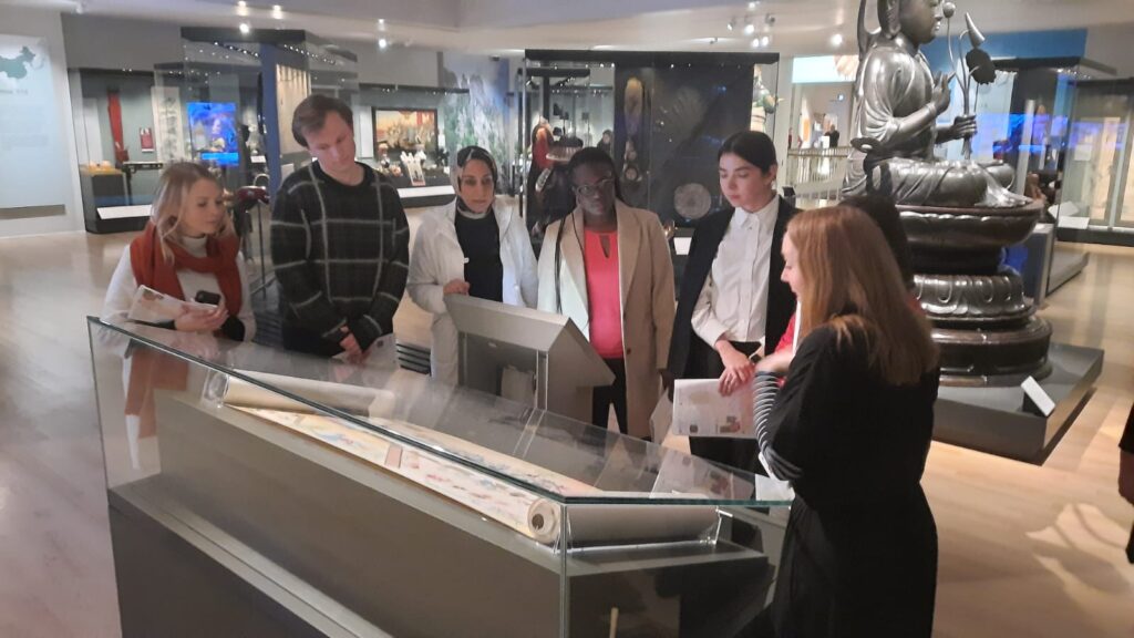 A group stand around an interactive museum display at National Museum of Scotland
