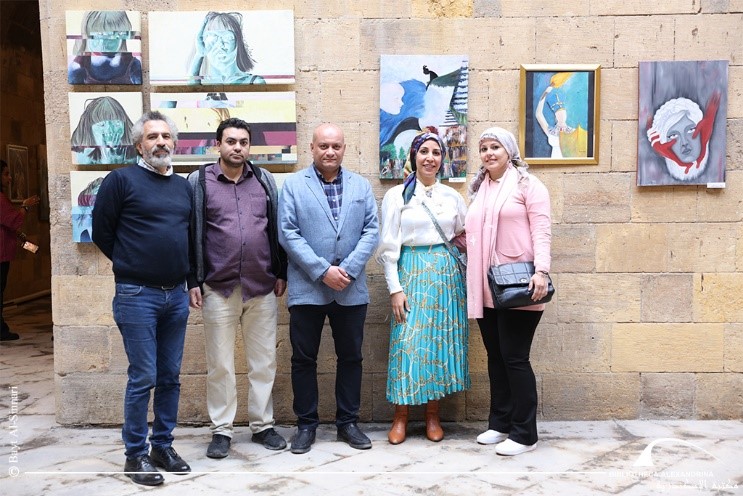 Nagwa and colleagues stand in a line for a group photo inside the exhibition