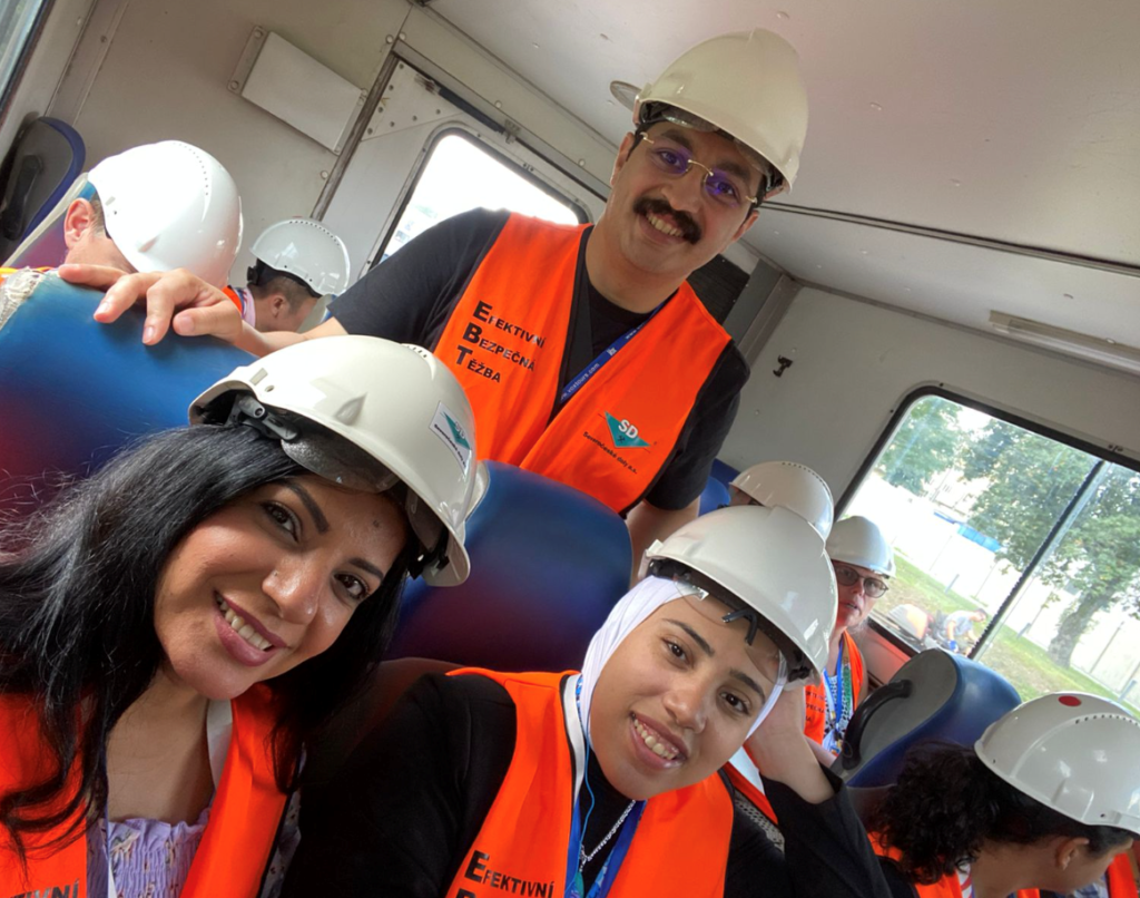 Wesam and two colleagues wearing luminous vests and hardhats. 