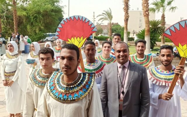 Yasser standing in a group men in traditional Nubian dress