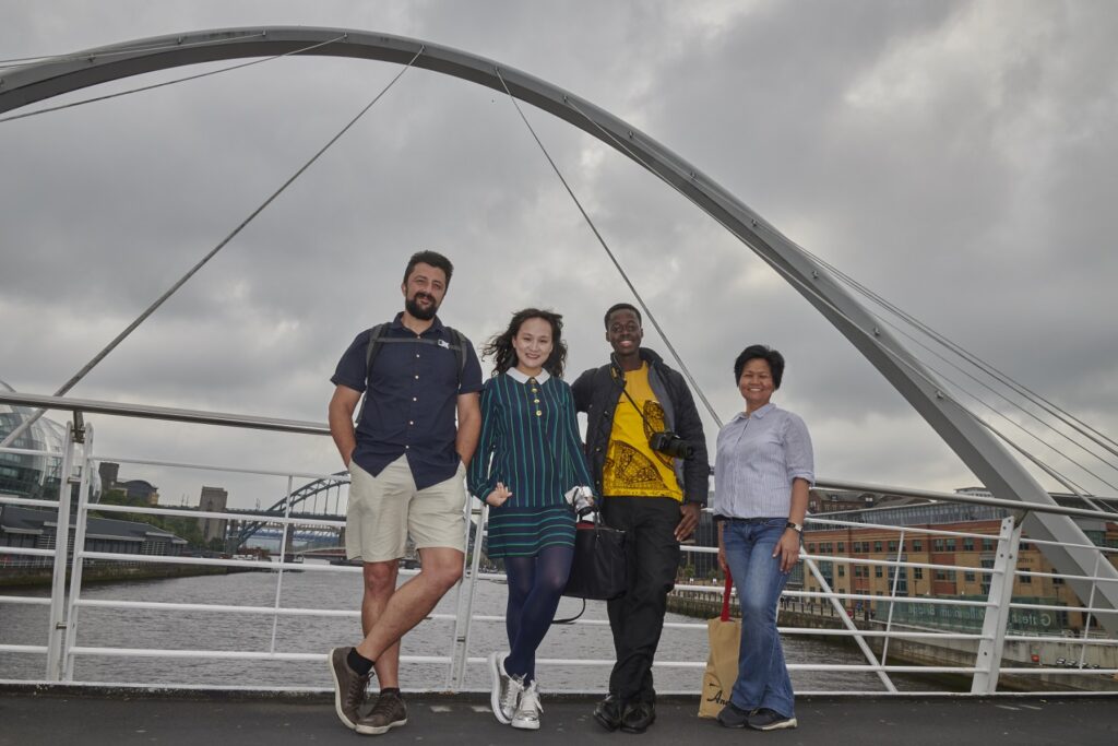 Ciprian standing next to three ITP colleagues on a bridge in Newcastle 