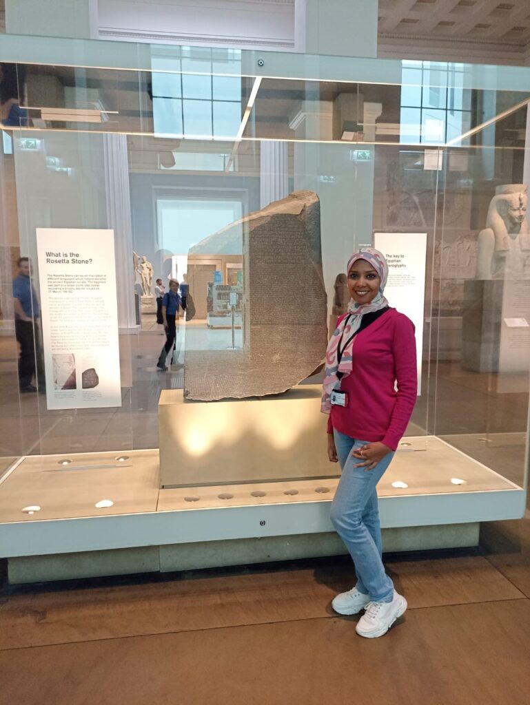 Dina standing next to the Rosetta Stone