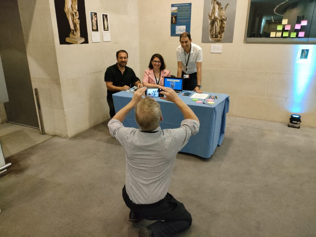 Thomas Kiely, curator of Ancient Greece and Cyprus, taking a photo of 2023 ITP fellows Ali Demirkiran, Elif Buyukgencoglu, and Aymen Chihaoui at the Object in Focus reception.