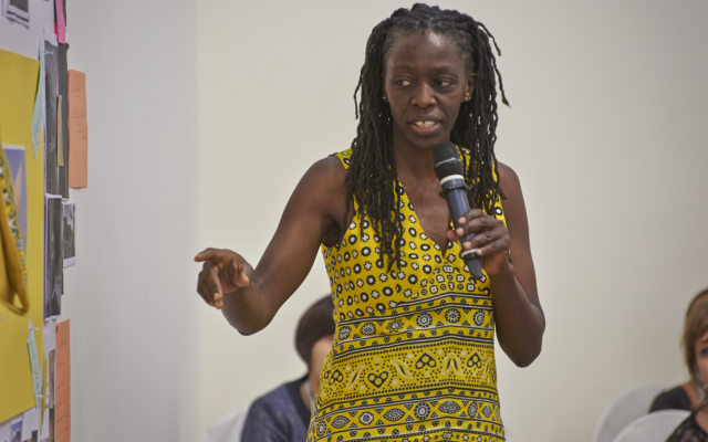 Eileen Musundi standing while holding microphone