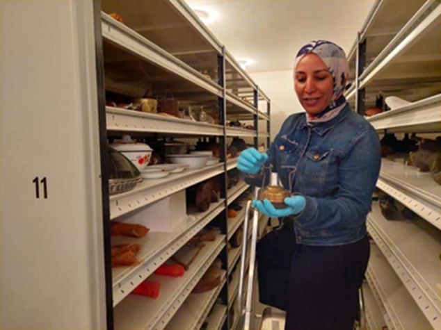 Nagwa Bakr handling an object inside a museum store