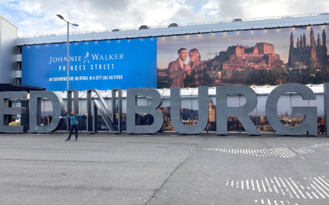 Rema standing in front of a huge 'Edinburgh' sign