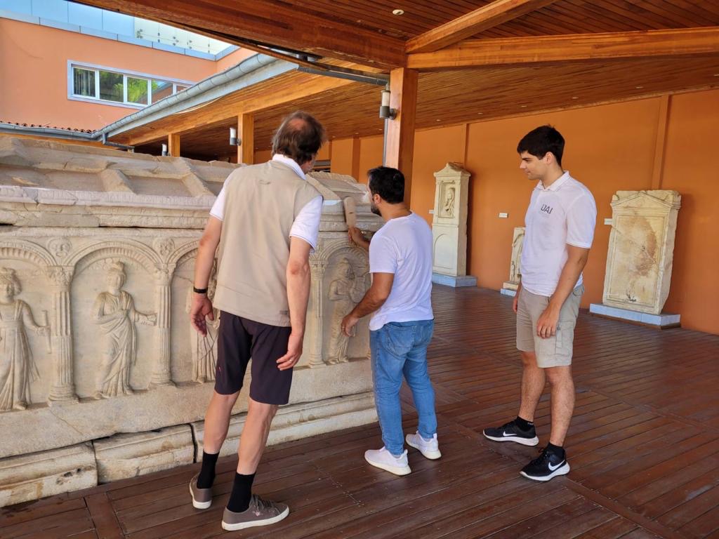 2023 ITP fellow Ali Demirkiran stood with two colleagues inspecting inscriptions in Ephesus.