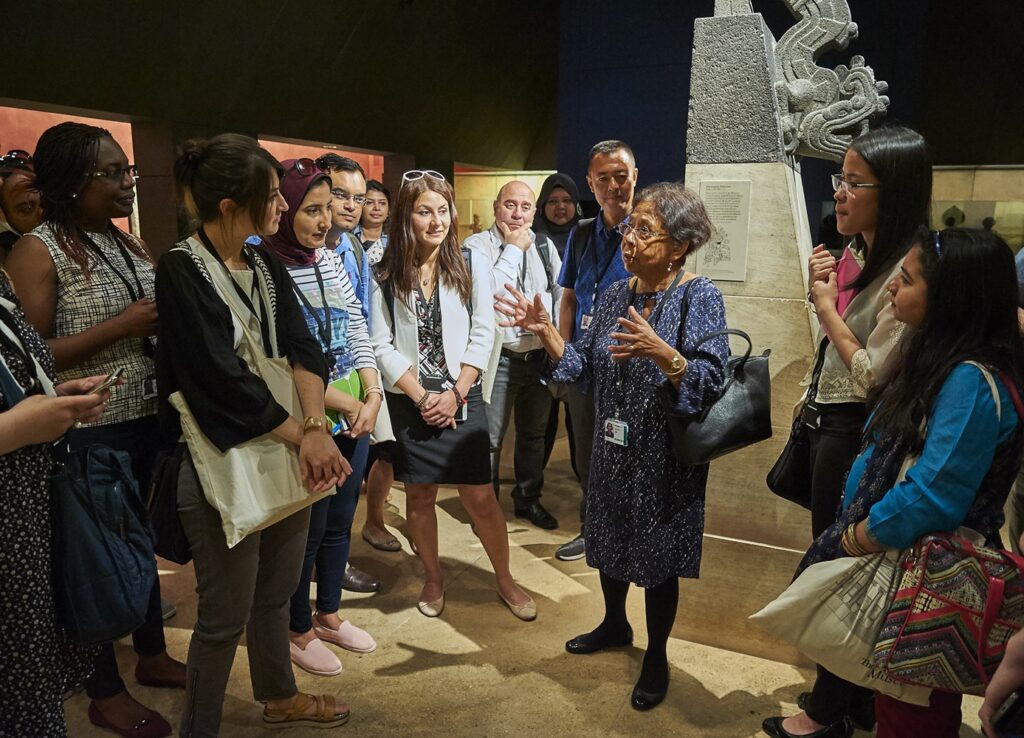 Kusuma pictured in the galleries at the British Museum, surrounded by ITP fellows, talking about objects.