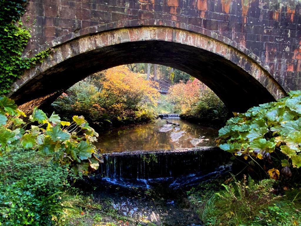 Photograph of a brick bridge over a stream