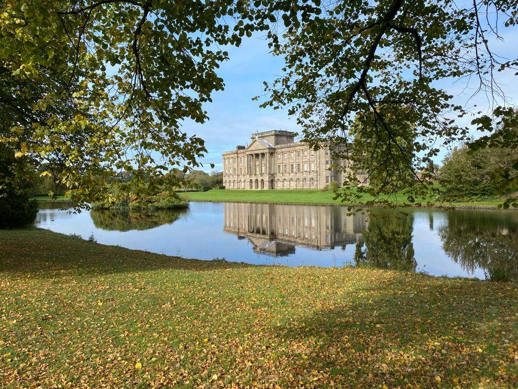 Photograph of the exterior of Lyme House, trough trees.