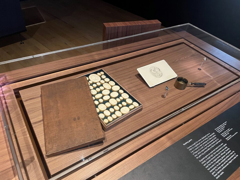 Photograph of a wooden case displaying a selection of casts in a wooden box resembling a book.