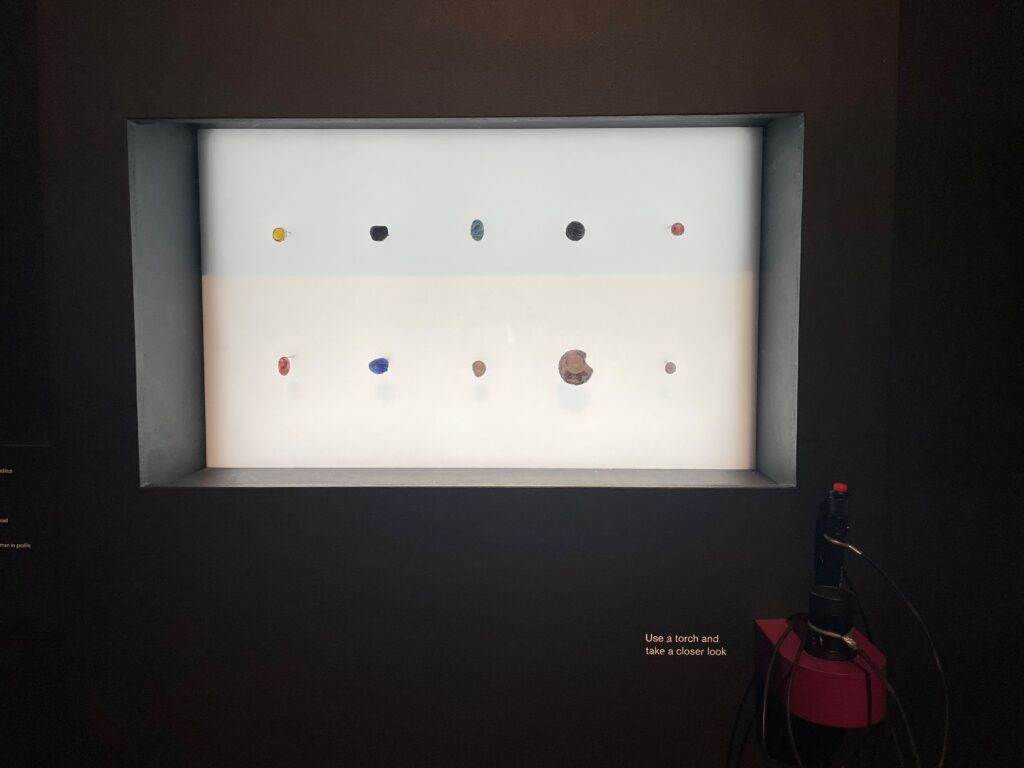 Photograph of a backlit case with 10 mounted gems.