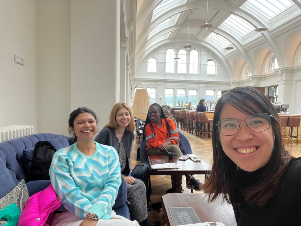 Photograph of four women sat around a table smiling.