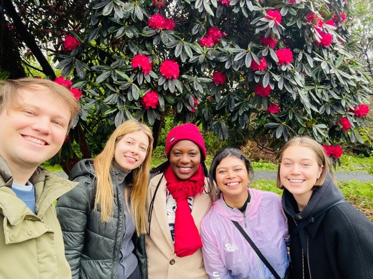 5 people stood in a line taking a selfie.