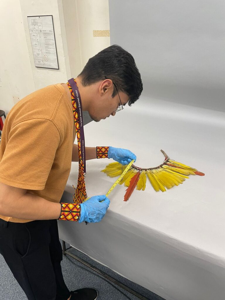 Photograph of Tarisson measuring a feather headdress.