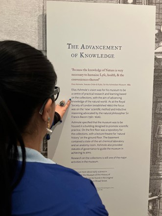 Photograph of someone reading a text panel.