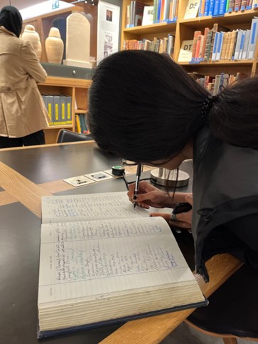 Photograph of someone writing in a book.