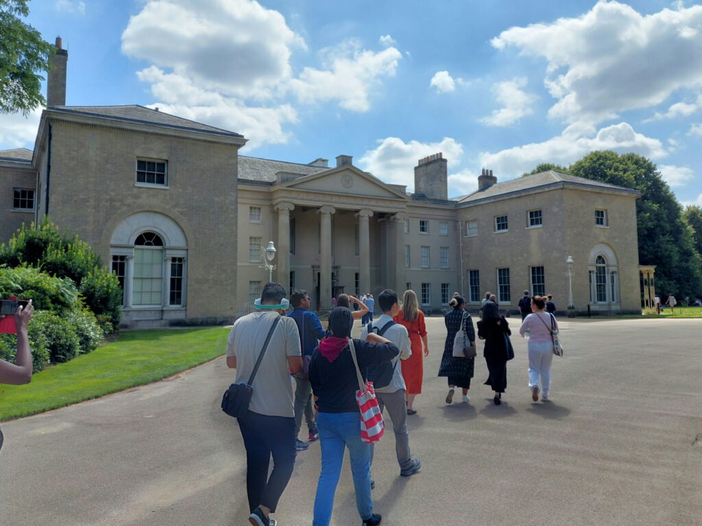 Photograph of a group of people walking towards Kenwood House
