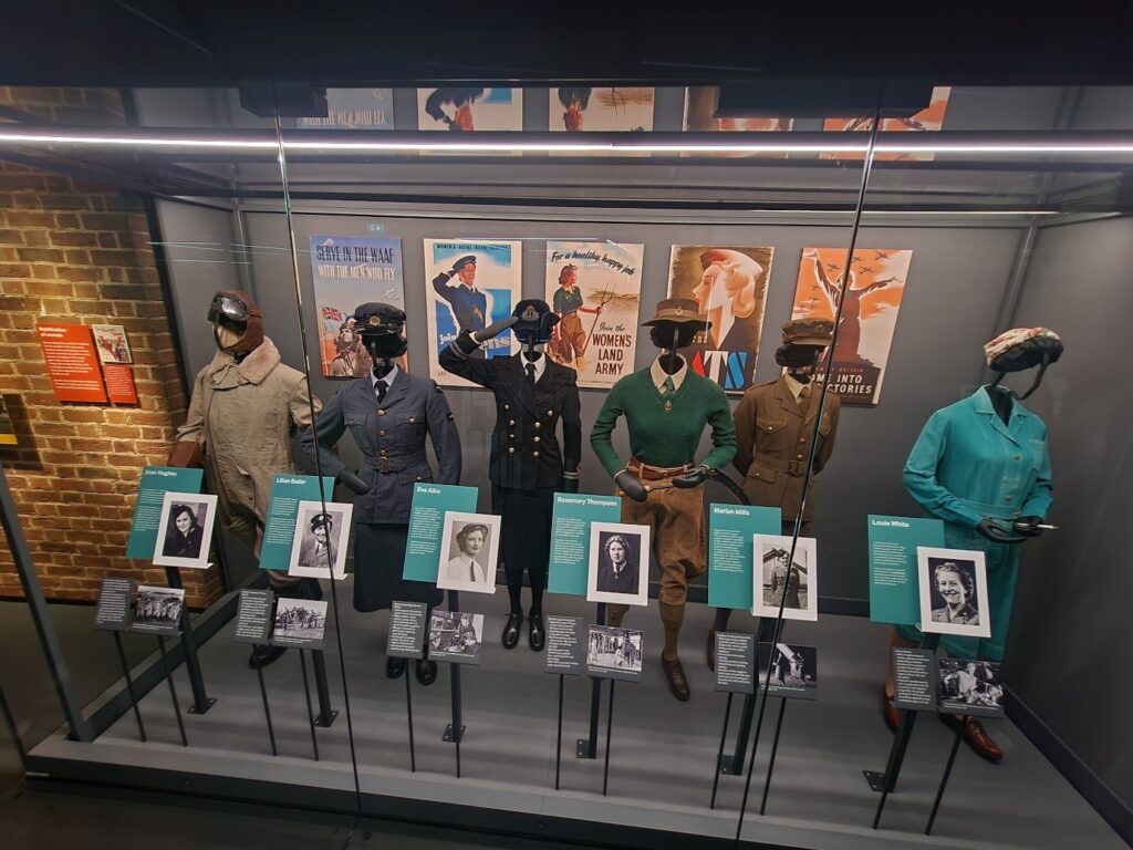 Photograph of a gallery showcase of women's uniforms.