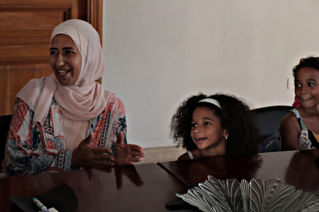 A woman and two children sat together smiling.