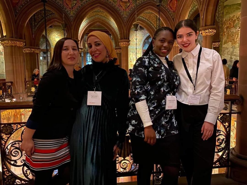 Photo of four people smiling
