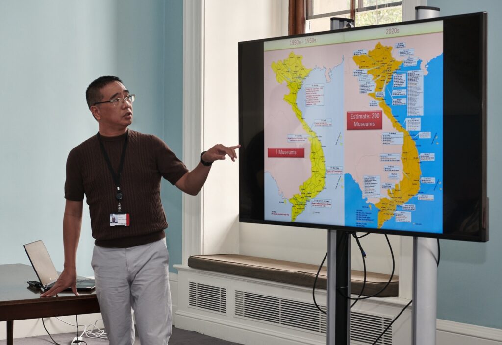 Photograph of a man pointing to a map of Vietnam