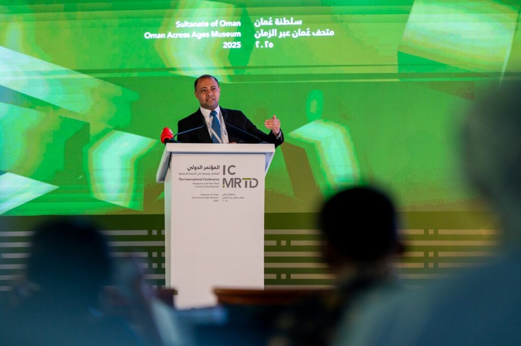 Photograph of a man speaking behand a podium.