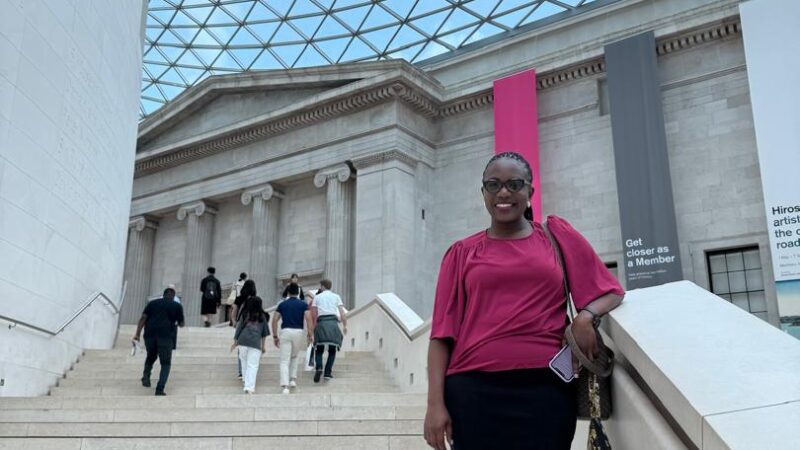 Photograph of a woman standing on the steps in the Great Court.