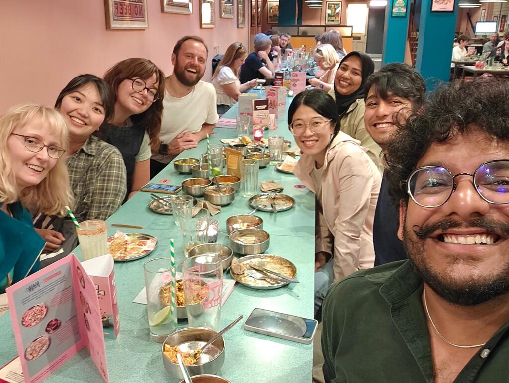 A group sat around a table taking a selfie