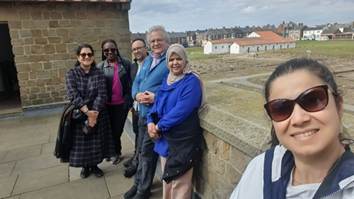 Photo of six people against a wall